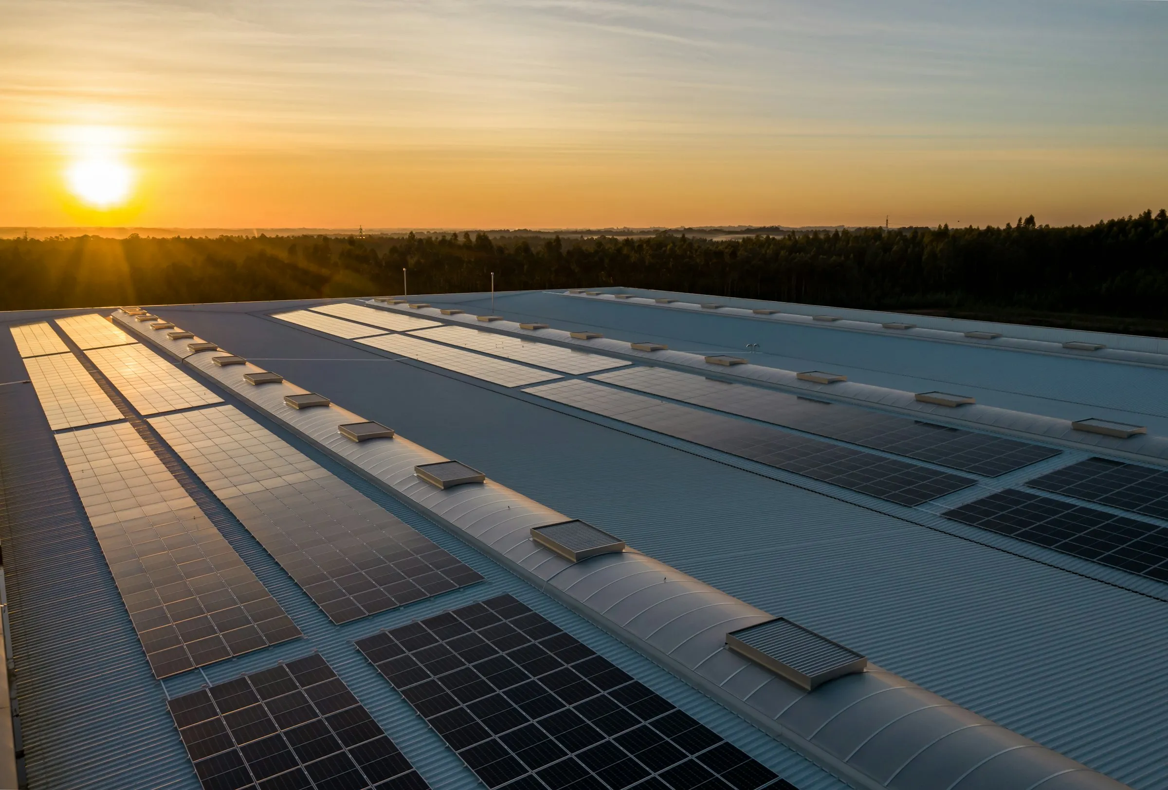 Solarni paneli na krovu objekta u zlatnom svjetlu zalaska sunca